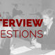 Many people in a room, sitting at tables, interviewing other people. Title - Ask better interview questions