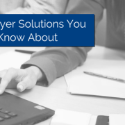 hand using the mouse on a laptop with papers on same table and a pen on top of papers. Pearls hanging from the person's neck tough the table with title - 3 Employer Solutions You Should Know About