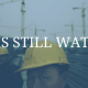 image of two constructions workers. One is looking straight into the photo. Text over image says, "OSHA is still watching."