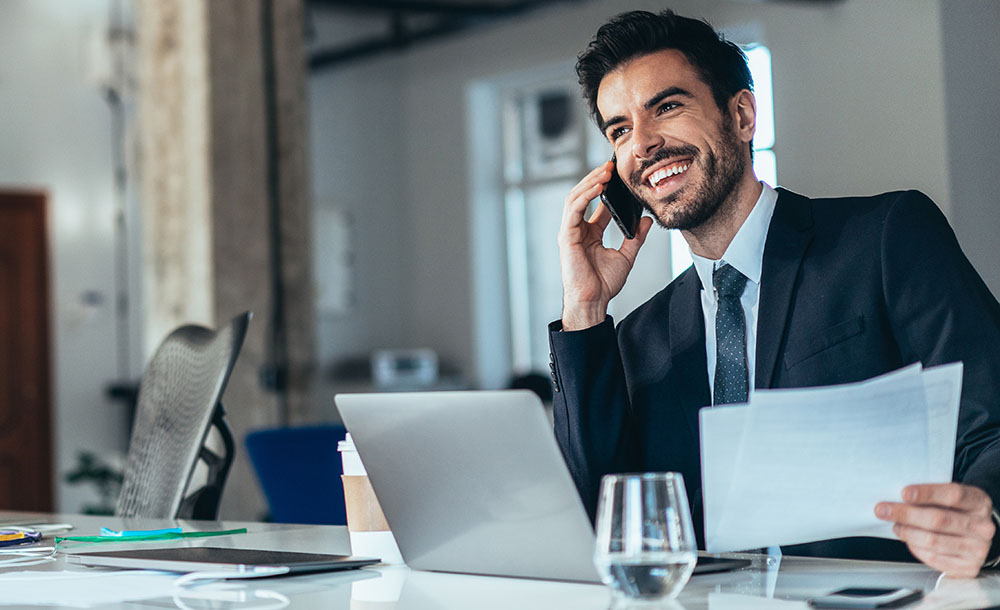 Portrait of Young successful businessman working on laptop and documents in the office